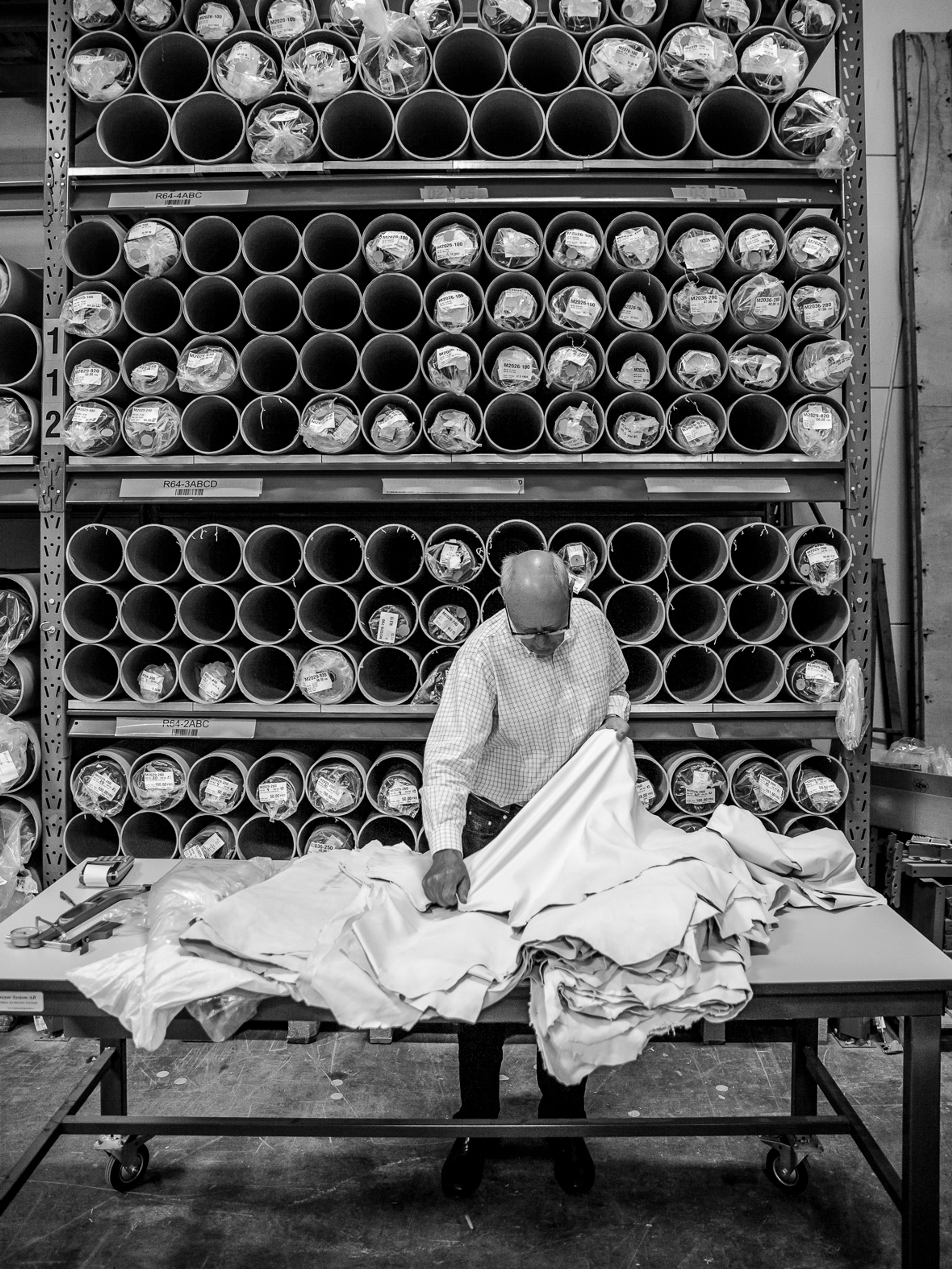 Inside our glove factory, with rows of workbenches and daylight through the windows